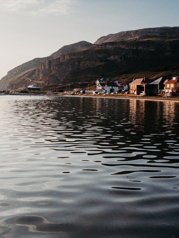 Discover the serene coastline of Llandudno, Wales with its stunning mountain backdrop and calm waters.