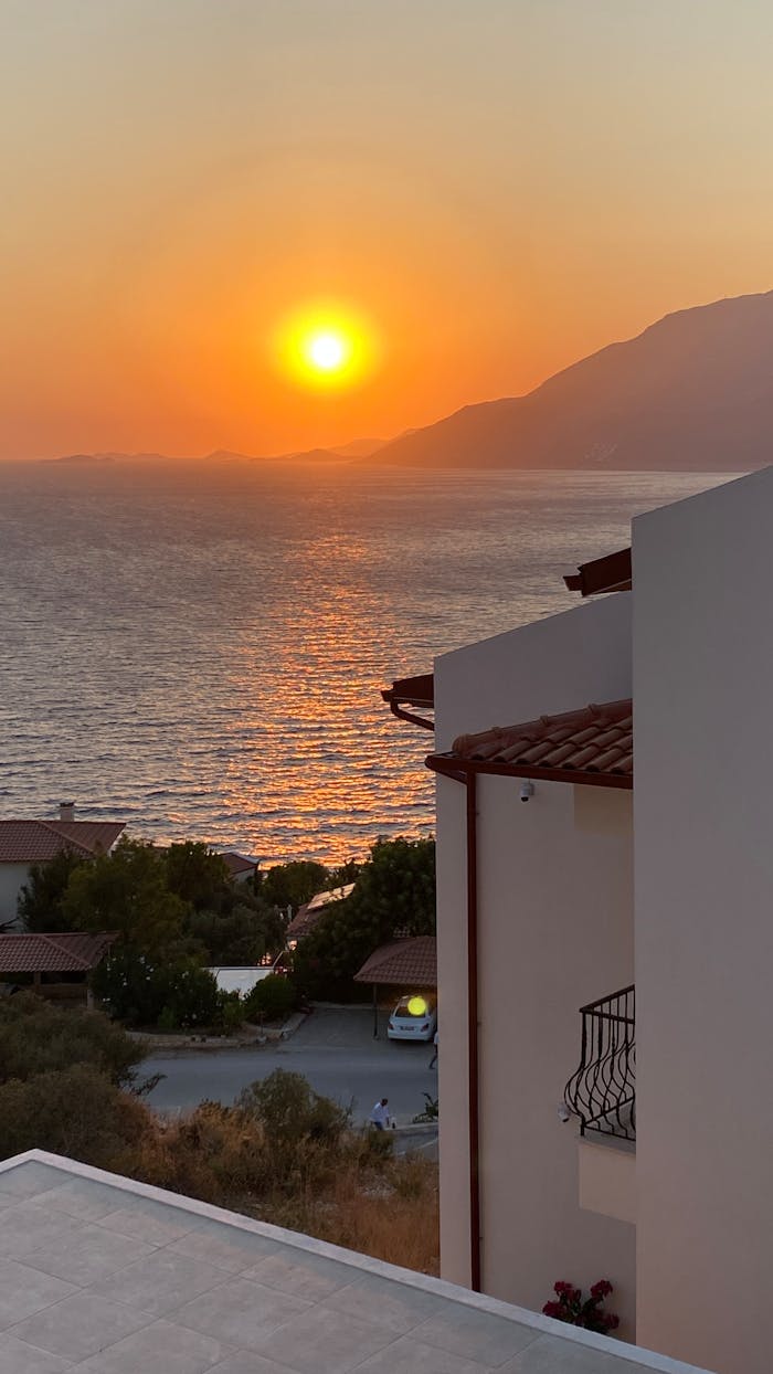 Stunning sunset view over the sea and coastal homes in Kaş, Antalya, Turkey.